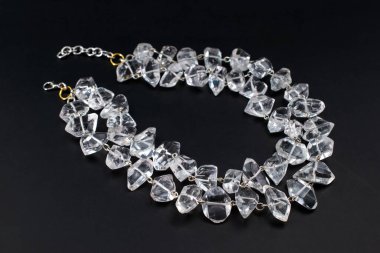 Yakından çekilmiş siyah bir arkaplanda kolye, mücevherler.