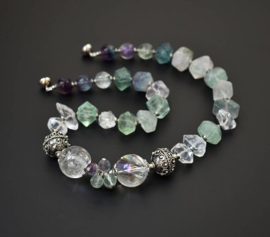 Siyah arka planda kolye yakın plan, ametist ve turkuaz.