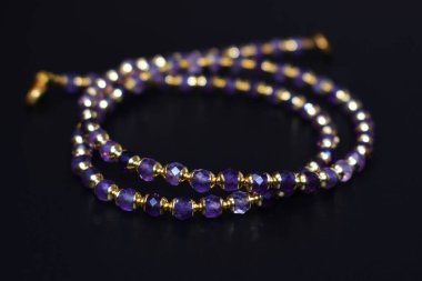 Siyah arka planda değerli taşlar olan kolye.