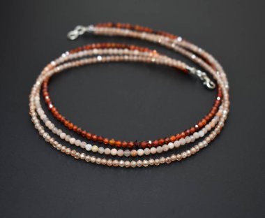 Siyah arka planda kolye, yakın plan. Doğal taşlardan yapılmış bilezik.