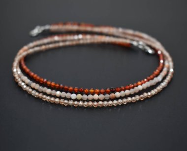 Siyah arkaplanda çeşitli renkte boncuklardan yapılmış bilezik.