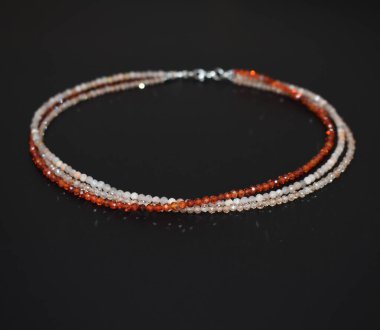 Yakından çekilen siyah arkaplanda sığ alan derinliğinde bir kolye.