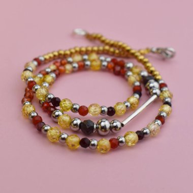 Pembe arka planda kolye yakın plan, kadınlar için renkli boncuklar.