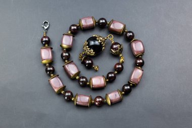 Siyah bir zemin üzerinde doğal taş boncuklardan yapılmış kolye..