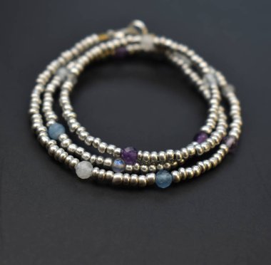 Siyah arka planda doğal taşlardan yapılmış bir kolye.