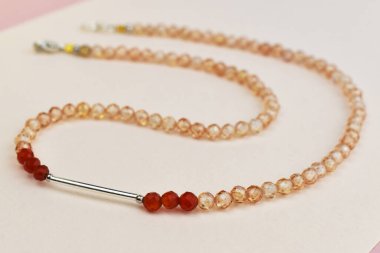 Pembe arka planda farklı renkte güzel boncuklar.