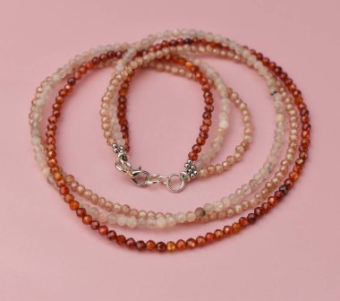 yakın plan pembe arkaplanda kolye ve kopyalama alanı