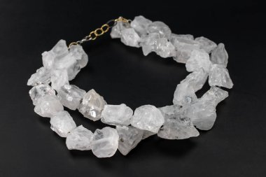 Siyah arka planda beyaz kuvarstan yapılmış kolye.