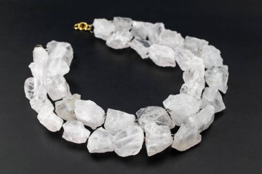 Siyah arka planda beyaz kuvarstan yapılmış kolye.