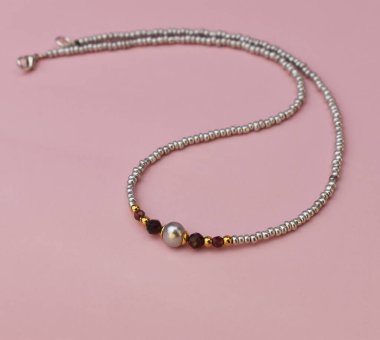 Yakın planda pembe arka planda bir kolye. Stüdyo fotoğrafı