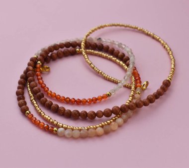 Pembe arka planda farklı renklerin kolyesi