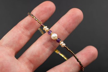 Siyah arka planda doğal taşlardan yapılmış bir bilezik..