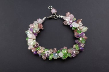 Siyah arkaplanda çok renkli mücevherler olan bilezik..