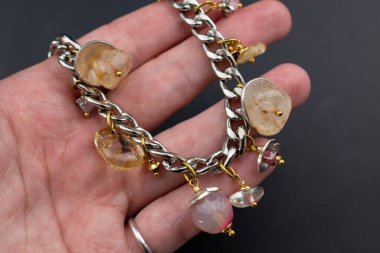 Karanlık bir arka planda doğal değerli taşlardan yapılmış bir bilezik.