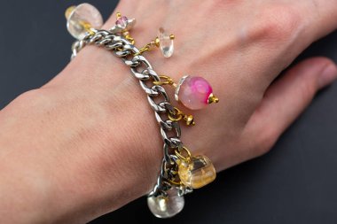 Bilezik ve boncuklarla bir kadının elinin yakın çekimi.