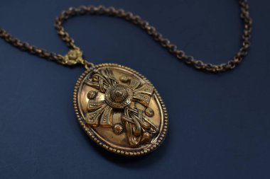 Koyu mavi arka planda tespihi olan klasik metal madalyon.