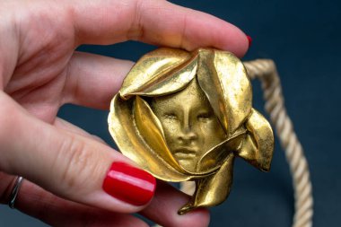 Altın Mısırlı maskesi genç bir kadının ellerinde.