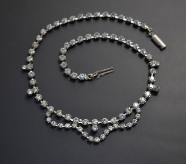 Siyah bir arkaplanda kolye, yakın plan, saatli.