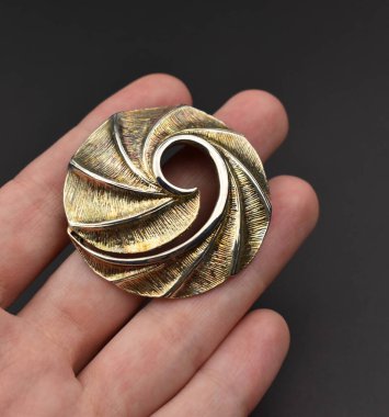 Siyah arka planda altın broş. Mücevher aksesuarları.