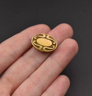 Koyu bir arka planda altın bir rozet. Mücevher konsepti.