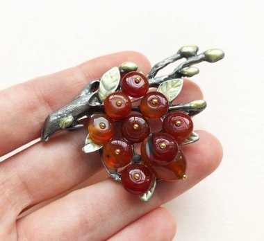 Beyaz arka planda kırmızı frenk üzümünden yapılmış el yapımı broş..