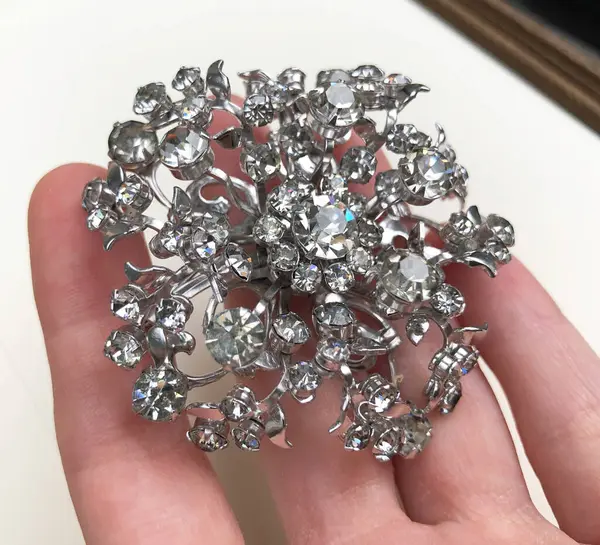 Mücevher broşu beyaz arka planda yakın plan çekimde.