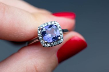 Bir kadının elinde mavi safir taşlı bir yüzük.