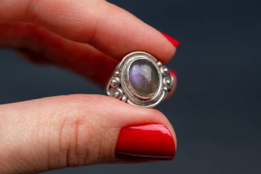 Genç bir kadının elinde safir yüzükle.