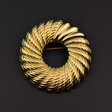 Siyah arka planda lüks altın broş, yakın plan.