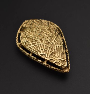 Siyah bir arkaplanda altın bir kolyenin yakın plan çekimi.