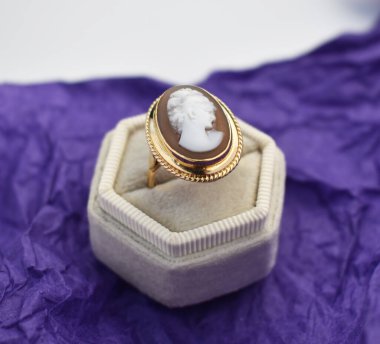 Mor arka planda beyaz taşlı bir mücevher yüzüğü.