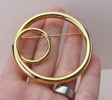 Beyaz arka planda altın broş. Yakın plan..