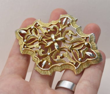 Çiçek şeklinde el yapımı altından bir broş.