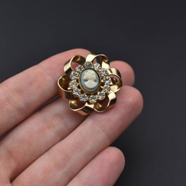 Altın yüzük, elinde değerli bir taş, siyah bir arka planda.