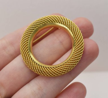 Beyaz arka planda altın broş, yakın plan..