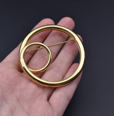 Koyu arkaplanda altın bir broş. Mücevher konsepti.