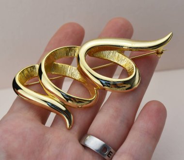 Beyaz arka planda altın broş. Mücevher konsepti.