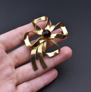 Siyah arka planda altın bir yay tutuyor, yakın plan.