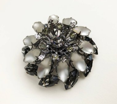 Beyaz arka planda yapay elmasları olan mücevher broşu.