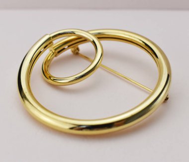 Beyaz arkaplanda altın broş. 