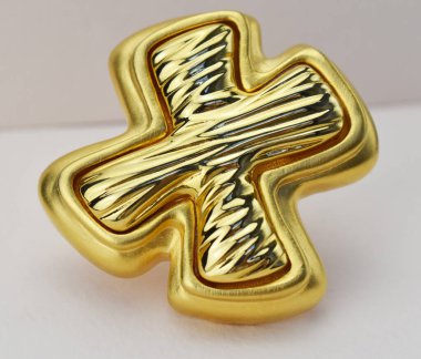 Beyaz bir arkaplanda izole edilmiş altın bir broşun yakın çekimi.