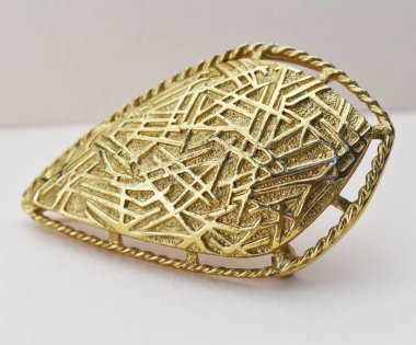 Beyaz arkaplanda izole edilmiş altın broş, yakın çekim.