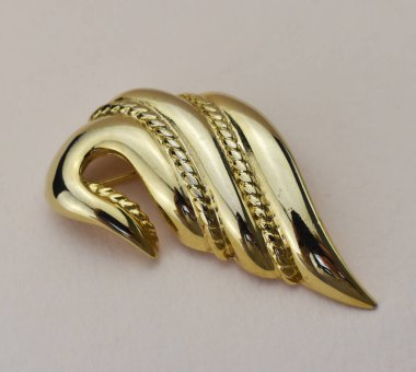 Fotokopi alanı olan gri bir arkaplanda altın bir broşu kapat