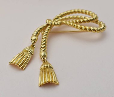 Beyaz arkaplanda altın broş, yakın plan, seçici odak