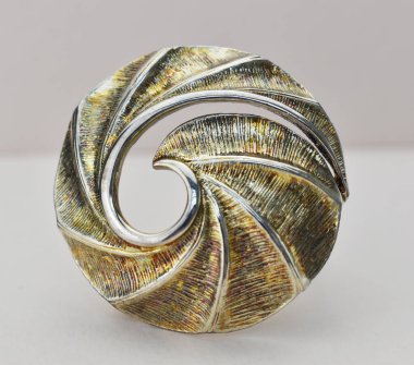 Beyaz arka planda metal bir broşun yakın plan çekimi..