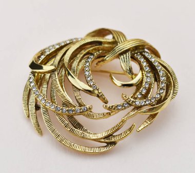 Beyaz arka planda elmaslı altın broş..