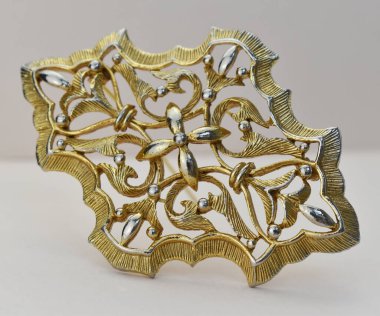 Beyaz arka planda izole edilmiş güzel, klasik altın bir broş. Stüdyo çekimi