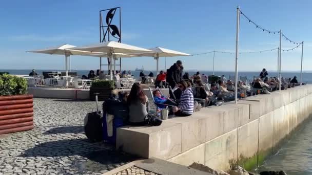 Pessoas Desfrutando Dia Ensolarado Nas Margens Rio Tejo Centro Lisboa — Vídeo de Stock