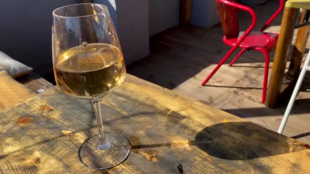 Una Copa Vino Blanco Proyecta Resplandor Mesa Madera Café Calle — Vídeo de stock