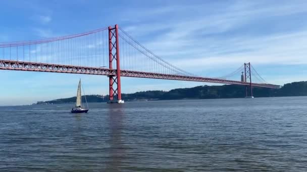 ポンテ デカルト橋と白い帆と小さなボート 日没で川上の帆船 現代建築 リスボン ポルトガル — ストック動画